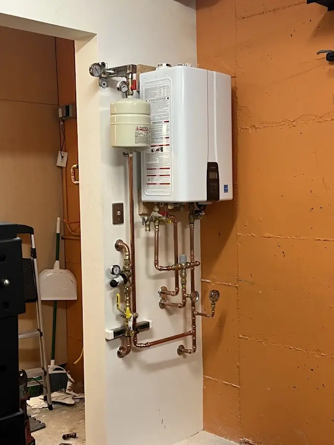 Plumbing technician inspecting water heater connections in Brooklyn Park